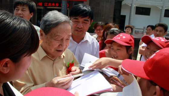 贺敬之在台儿庄中华文化促进会揭碑仪式上给小朋友签名